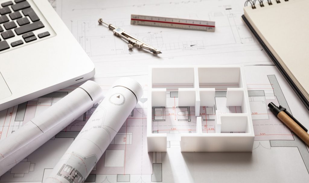 Construction concept. Residential building drawings and house model,