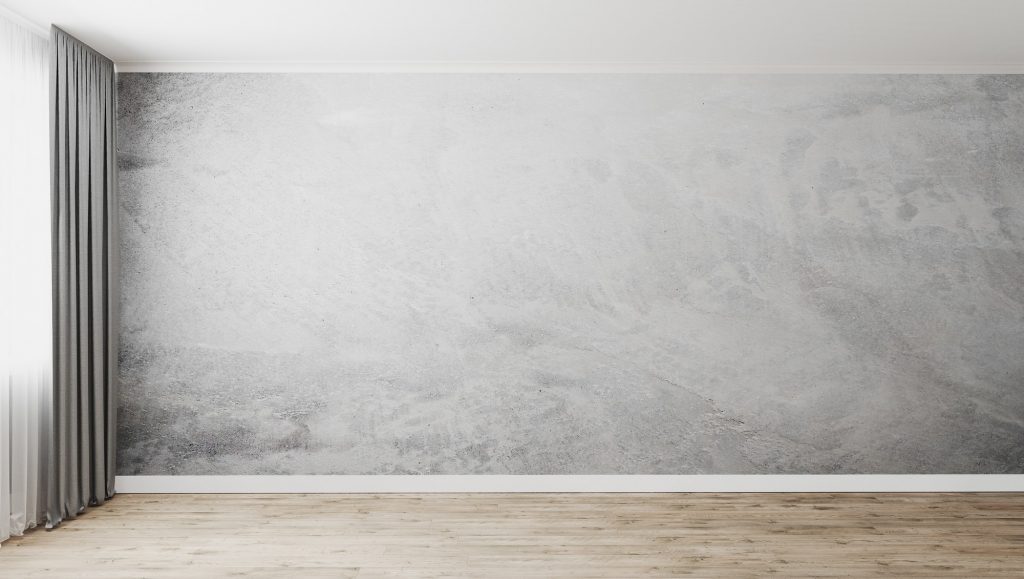 Empty room with gray decorative plaster wall and wooden floor
